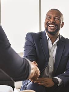 smiling man in suit shaking hands with a commercial lender