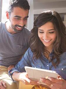 happy couple looking at mobile device reviewing  Marine Banks mortage rates
