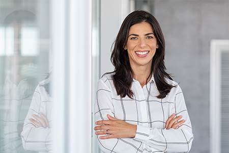 happy woman leaning against glass office door geting ready to meet her new lender